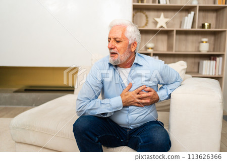 Pain on heart, heart attack. Unhappy middle aged senior man suffering from chest pain heart attack problems with health at home. Mature old senior grandfather touching chest experiencing infarction 113626366