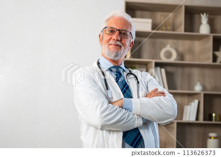 Mature senior male doctor in glasses medical uniform smiling looking at camera in hospital or doctor office. General practitioner GP therapist professional healthcare expert in clinic. Healthcare 113626373