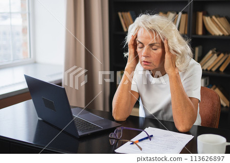 Headache pain. Middle aged woman touching temples experiencing stress. Mature old lady tired of work feeling headache sick rubbing temples forehead. Long laptop usage computer vision office syndrome 113626897