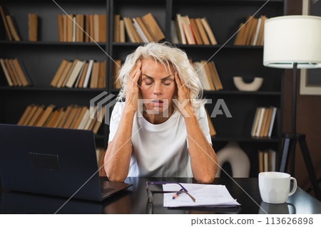 Headache pain. Middle aged woman touching temples experiencing stress. Mature old lady tired of work feeling headache sick rubbing temples forehead. Long laptop usage computer vision office syndrome 113626898