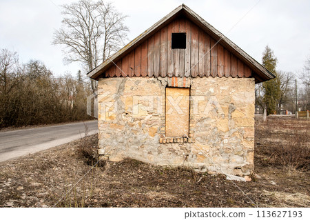Dolomite masonry building. Closed window with osb board. Street view Dolomite masonry building. Closed window with osb board. Street view 113627193