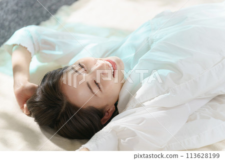 A woman lying in bed 113628199