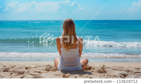 坐在海灘上的年輕女子的後視圖 113629712
