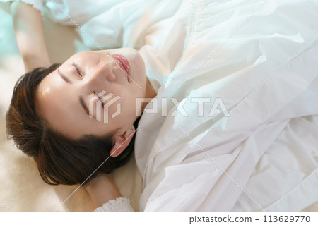Woman lying down and relaxing Woman lying down and relaxing 113629770