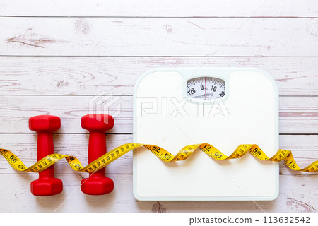 Weight loss control planning. White scale and measuring tape with dumbbell for body dieting healthy life. Weight loss control planning. White scale and measuring tape with dumbbell for body dieting healthy life. 113632542