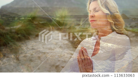 Digital composite of a Caucasian woman meditating near the beach with a view of the shore in the for Digital composite of a Caucasian woman meditating near the beach with a view of the shore in the for 113633063