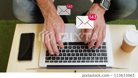 Digital composite of a man typing on his laptop on a desk with email icons increasing in count in th Digital composite of a man typing on his laptop on a desk with email icons increasing in count in th 113633065