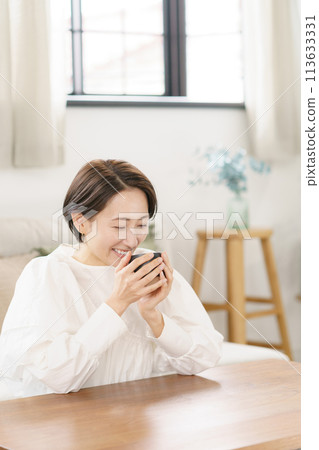 woman drinking coffee in the living room 113633331