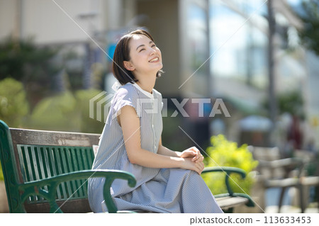 Young woman relaxing on a bench in the city 113633453