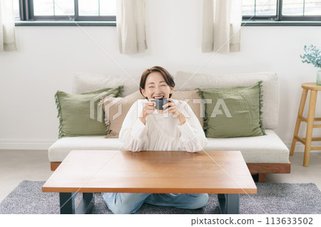 woman drinking coffee in the living room 113633502