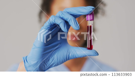Image of mathematical equations over biracial female doctor with test tube 113633903
