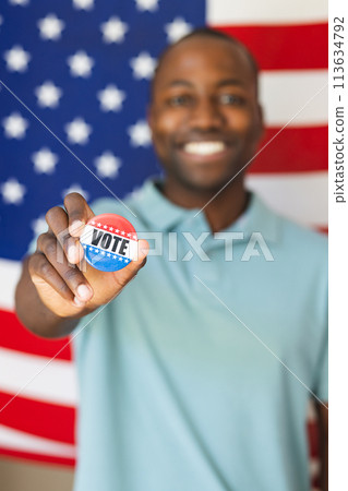 Young African American man shows a 'vote' badge proudly, with copy space 113634792