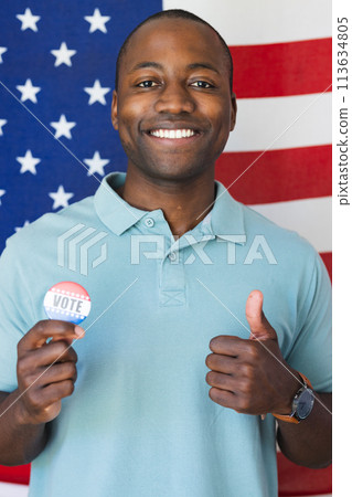 Young African American man shows his support for democracy with a 'vote' badge 113634805