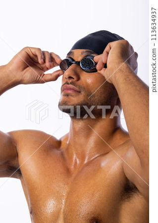 Young biracial male swimmer adjusts his goggles Young biracial male swimmer adjusts his goggles 113634937