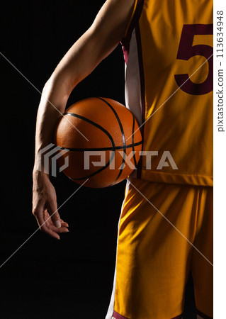 Basketball player in action on a dark background with a black background 113634948