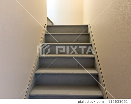 Discover the typical construction of an unfinished staircase leading to the basement of a suburban house, showcasing the raw materials and construction process. Discover the typical construction of an unfinished staircase leading to the basement of a suburban house, showcasing the raw materials and construction process. 113635061