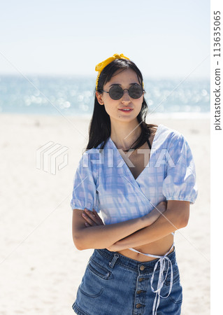 Young biracial woman stands confidently on the beach 113635065