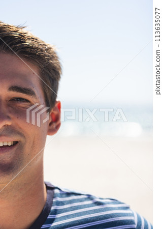 A young Caucasian man smiles at the beach, with copy space A young Caucasian man smiles at the beach, with copy space 113635077