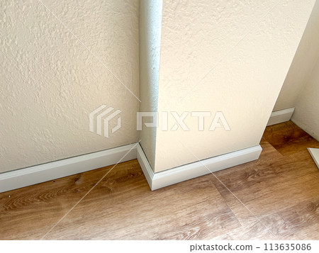 Witness the professional installation of vinyl baseboards in a stylish modern home, adding a sleek finishing touch to the interior design. Witness the professional installation of vinyl baseboards in a stylish modern home, adding a sleek finishing touch to the interior design. 113635086