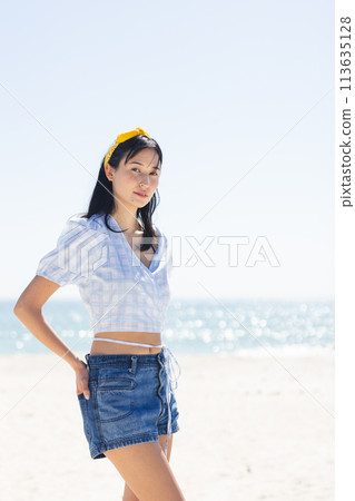 Young biracial woman poses on a sunny beach, with copy space Young biracial woman poses on a sunny beach, with copy space 113635128