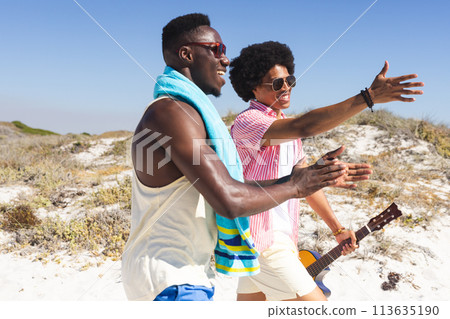Young African American men enjoy a sunny beach day 113635190