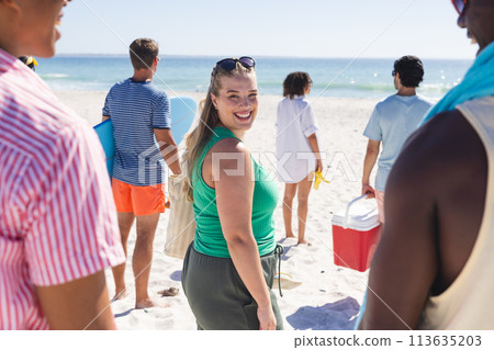Young Caucasian woman enjoys a sunny beach day with friends 113635203