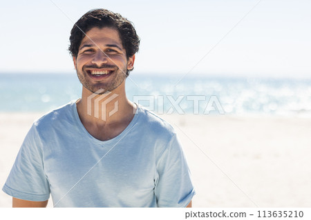 Young biracial man smiles brightly at the beach 113635210