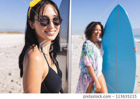 Young biracial women enjoy a sunny beach day 113635215