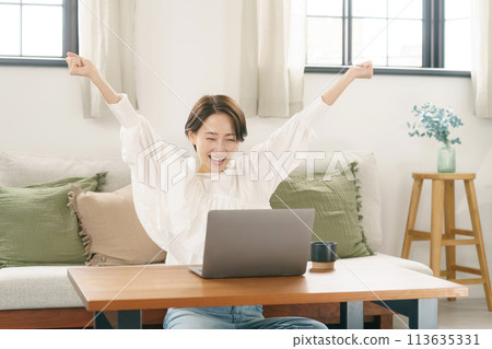 A woman in her 30s using a computer in the living room A woman in her 30s using a computer in the living room 113635331