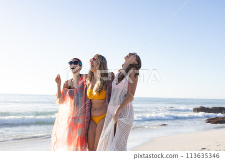 Three young women enjoy a sunny beach day Three young women enjoy a sunny beach day 113635346