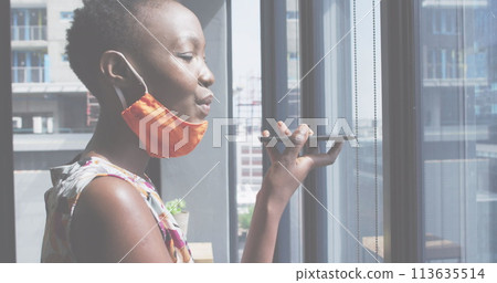 Image of financial data processing over businesswoman with face mask using smartphone in office 113635514