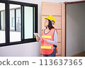 Professional women home Inspector surveyor wearing vests and hard hat at new property 113637365