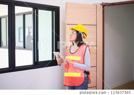 Professional women home Inspector surveyor wearing vests and hard hat at new property Professional women home Inspector surveyor wearing vests and hard hat at new property 113637365