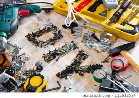 DIY abbreviation composed of screws and self-tapping screws, surrounded by various construction tools 113638554