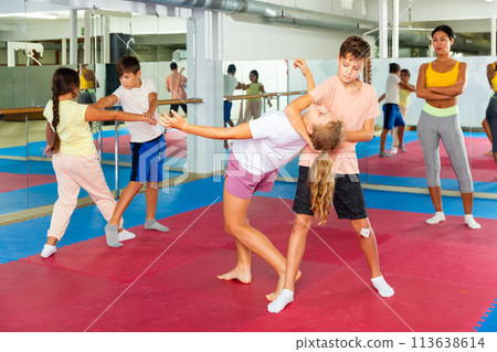 Group of kids training self-defence moves in gym 113638614