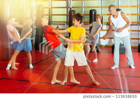 Kids in pairs training self-defence moves Kids in pairs training self-defence moves 113638650