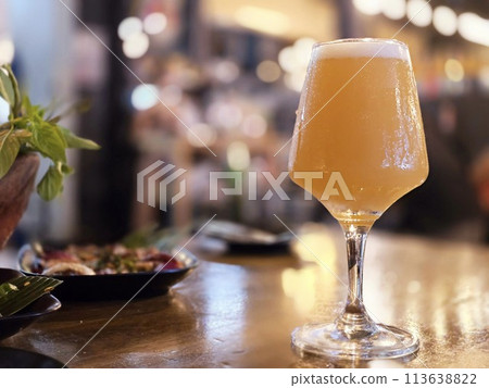 Cold beer in a glass, Wooden table and dark interior of bar. Cold beer in a glass, Wooden table and dark interior of bar. 113638822
