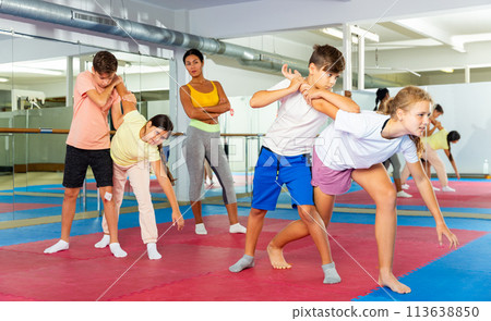 Kids in pair exercising self-defense movements Kids in pair exercising self-defense movements 113638850