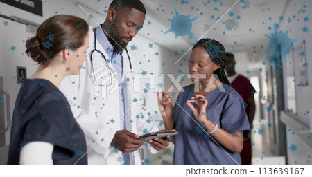 Image of floating viruses over diverse doctors talking in hospital corridor 113639167