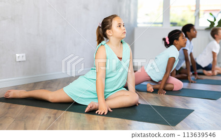 Young girl doing yoga in group of children 113639546