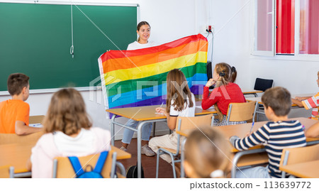 Female teacher explaining lgbt theme to children during lesson in class in secondary school Female teacher explaining lgbt theme to children during lesson in class in secondary school 113639772