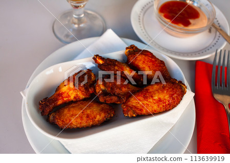 Tasty crispy grilled chicken wings on plate 113639919
