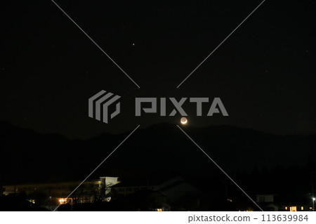地球照耀的月亮和木星落在山和城市燈光的邊緣 地球照耀的月亮和木星落在山和城市燈光的邊緣 113639984