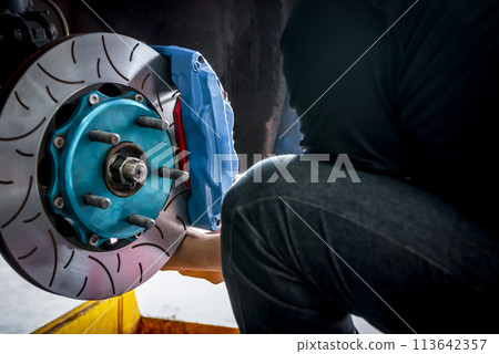 Checking car brake system for repair at car garage Checking car brake system for repair at car garage 113642357