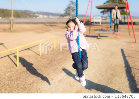 A girl playing in the park's Tarzan rope 113642703