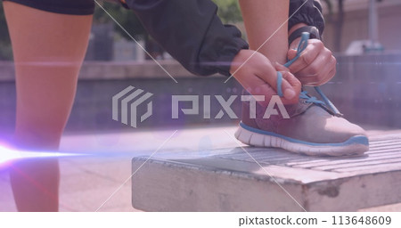 Image of light moving over feet of woman in shorts tying running shoe Image of light moving over feet of woman in shorts tying running shoe 113648609