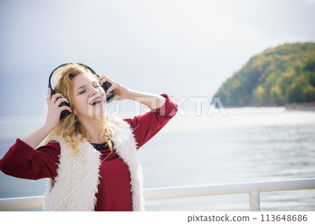 Happy woman wearing headphones outdoor 113648686