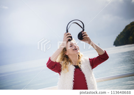 Happy woman wearing headphones outdoor Happy woman wearing headphones outdoor 113648688