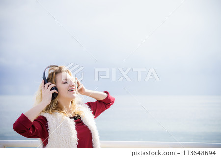 Happy woman wearing headphones outdoor Happy woman wearing headphones outdoor 113648694