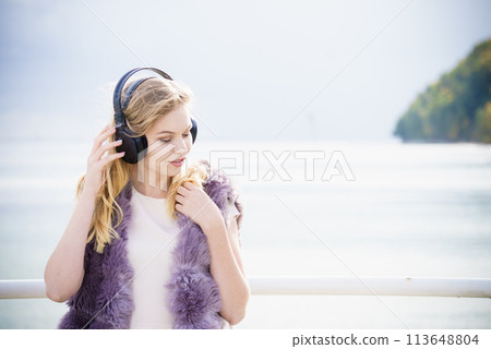 Happy woman wearing headphones outdoor Happy woman wearing headphones outdoor 113648804